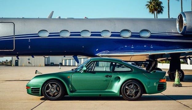 Classic green Porsche in front of a jet